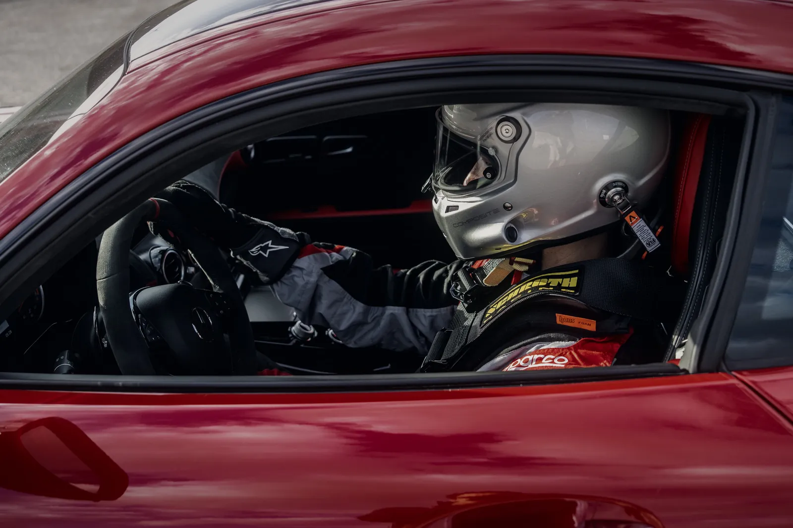 Driver in helmet and harness at the wheel of the Mercedes-AMG GT R